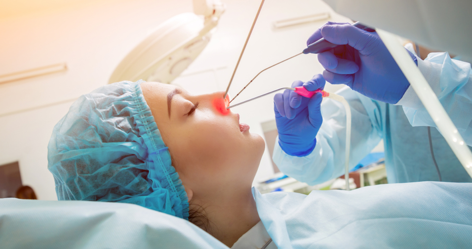 The surgical tram is using a tool to operate tumour on a patient through the nasal passage.